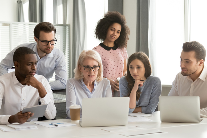 Diverse employees cooperating discussing business project together